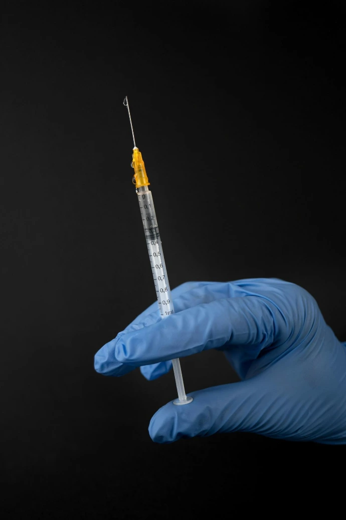 person in white pants and white shirt holding clear glass tube